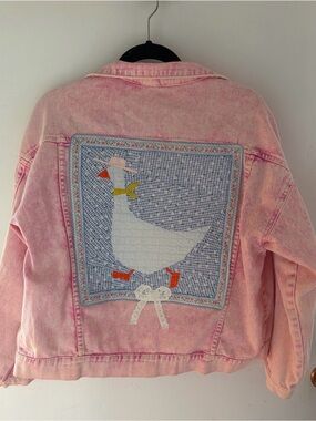Upcycled pink Jean jacket with a quilted cowboy goose with a lace bow on the bac